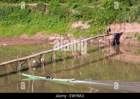 Mönch auf Fußgängerbrücke über Nam Khan Fluss, Luang Prabang, Laos Stockfoto