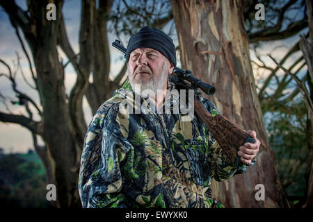 Erfahrener Jäger ruht eine Gewehr auf der Schulter Stockfoto