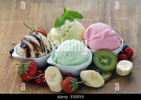Gemischte Eis Erdbeere, Banane, Minze, Schokolade und frischen Beeren auf dem Holztisch Stockfoto