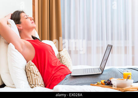 Schlafend junge Frau mit einem Computer auf den Knien Stockfoto