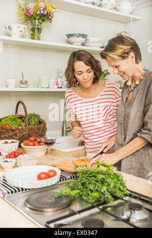 Ältere Frau und Tochter Zubereitung frisches Gemüse in der Küche Stockfoto