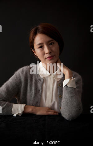 Porträt der Frau am Tisch sitzen Stockfoto