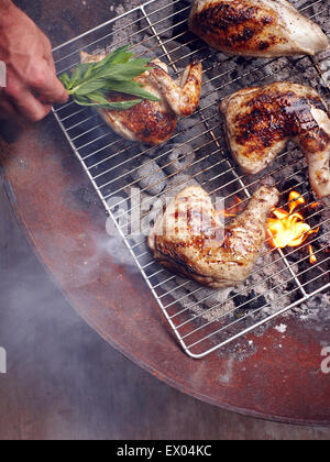 Mans Hand Guam Hähnchenschenkel auf Grill Grillen Stockfoto