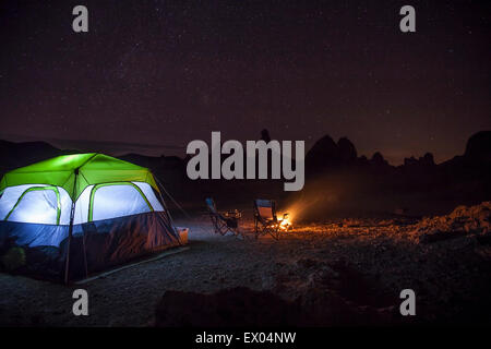 Zelt und Lagerfeuer vor Trona Pinnacles in der Nacht, Trona, Kalifornien, USA Stockfoto