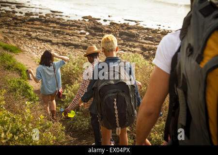 Gruppe von Freunden zu Fuß hinunter in Richtung Strand, Rückansicht Stockfoto