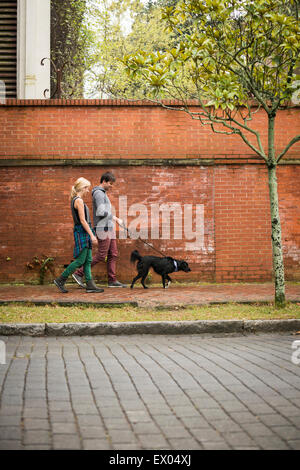 Paar walking Hund auf Bürgersteig, Savannah, Georgia, USA Stockfoto