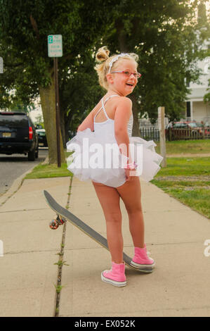 Junges Mädchen Stiefeln Tutu und rosa Baseball, stehend auf skateboard Stockfoto