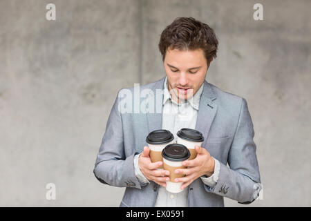 Geschäftsmann hält Einweg Kaffeetassen Stockfoto