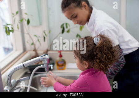 Mädchen beobachten Kleinkind Händewaschen Stockfoto