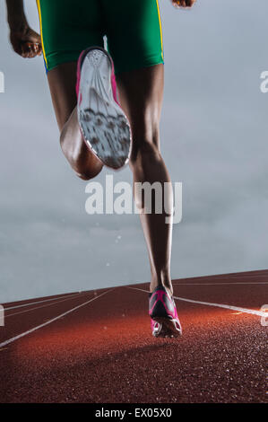 Rückansicht des jungen Athletinnen Beine laufen auf Rennstrecke Stockfoto