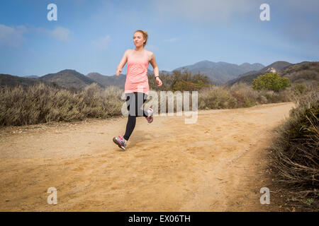 Junge Frau läuft Dirt-track Stockfoto