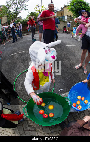 Kinder genießen das Spiel und Spaß in einer Londoner Straße Kostümfest Stockfoto