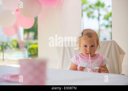 Kleines Kind trinken Saft aus Pappbecher Stockfoto