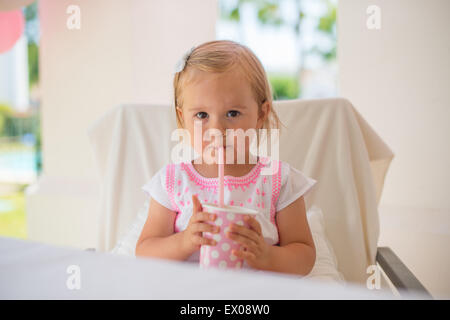 Kleines Kind trinken Saft aus Pappbecher Stockfoto