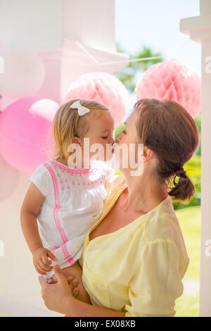 Dicken Kuss gibt niedliche kleine Tochter Mutter Stockfoto