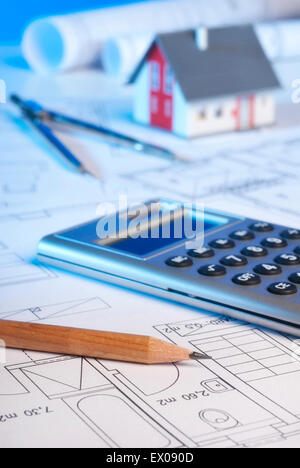 Architekturmodell mit Blaupausen, Taschenrechner, Zirkel und Stift. Stockfoto