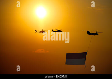 Singapur 50. National Day Parade Militärhubschrauber Vergangenheit mit Singapur Flagge bei Sonnenuntergang Stockfoto