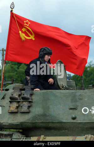 Re-Enactor gekleidet als sowjetische Panzerkommandant mit Flagge der Sowjetunion Stockfoto