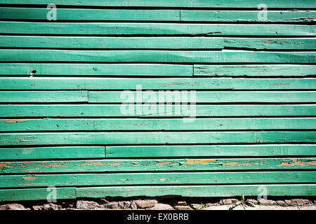 Abblätternde grüne Farbe an verwittertem Holz Wand Stockfoto