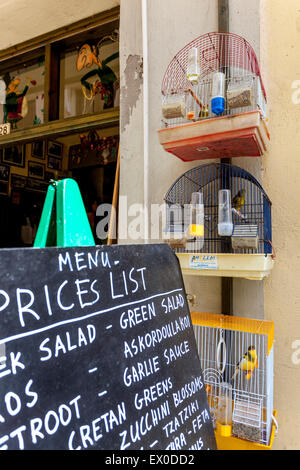 Kreidetafel-Menü und kanarische Vogelkäfige außerhalb der Bar Kreta Rethymno Altstadt Kreta Taverna Griechenland Stockfoto