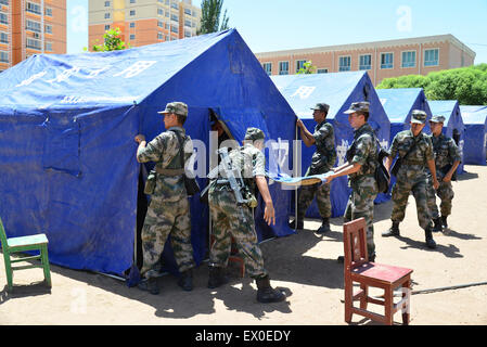 Pishan, Chinas Xinjiang Uygur Autonome Region. 3. Juli 2015. Soldaten von Lanzhou militärisches Sperrgebiet Befehl tragen Aufmachungen Relief Zelte in Erdbeben betroffenen Pishan Grafschaft, Nordwesten Chinas Xinjiang Uygur Autonome Region, 3. Juli 2015. Chinesische Behörden haben eine Klasse-IV-Notfallmaßnahmen zu einem Erdbeben der Stärke 6,5 initiiert, die am Freitag in Xinjiang sechs Menschen getötet worden. Bildnachweis: Mao Dehai/Xinhua/Alamy Live-Nachrichten Stockfoto