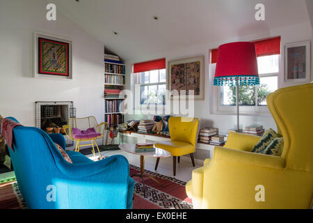 Kühnen blauen Sofa, Julep Stuhl und Eames Wire Schaukelstuhl im Wohnzimmer mit Aborigines Wandkunst Stockfoto