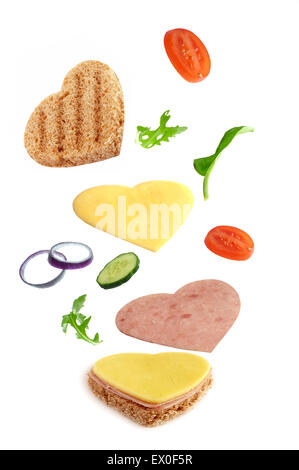 Herz-Form-Sandwich-Zutaten fallen an ihren Platz Stockfoto