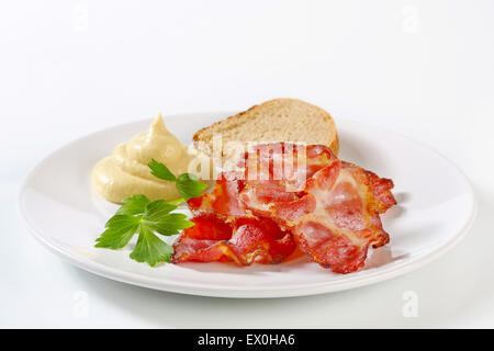 Knusprige Speckscheiben mit Brot und Senf-sauce Stockfoto