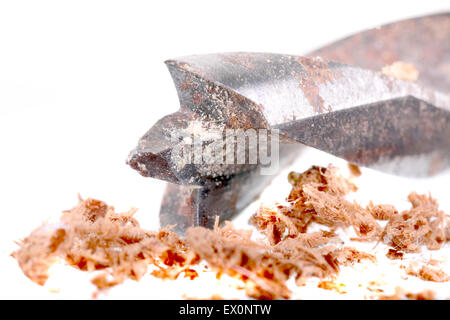 Makroaufnahme einer alten rostigen Bohrer und Holzspäne auf weiß Stockfoto