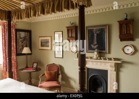 Georgische vier Himmelbett im Schlafzimmer mit Louis XV Sessel und Kamin Stockfoto