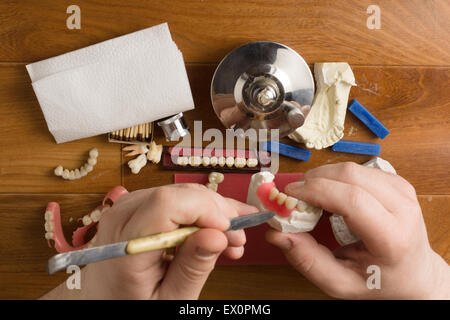 der Zahntechniker beschäftigt sich mit einer Modellierung von Zahnersatz Stockfoto