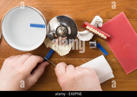 der Zahntechniker beschäftigt sich mit einer Modellierung von Zahnersatz Stockfoto