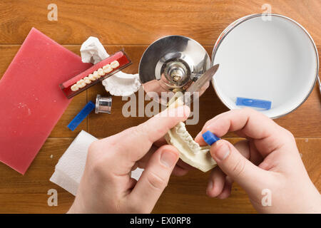 der Zahntechniker beschäftigt sich mit einer Modellierung von Zahnersatz Stockfoto