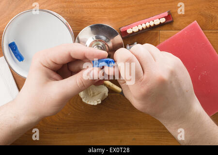 der Zahntechniker beschäftigt sich mit einer Modellierung von Zahnersatz Stockfoto