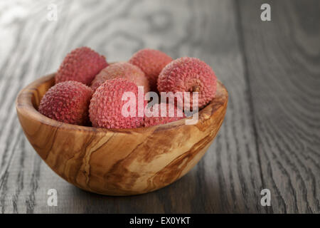 Reife Litschis in Holz Schüssel auf Tisch Stockfoto