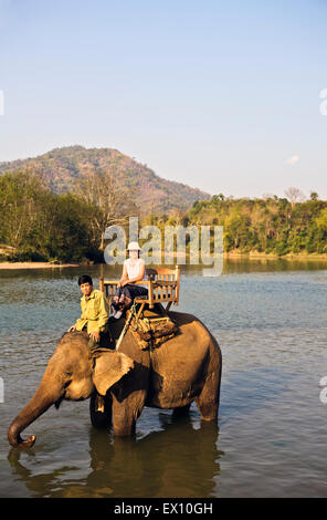 Lao Frau und Mahout Elefantenritt ein auf dem Khan Fluss. Luang Prabang, Laos. Stockfoto