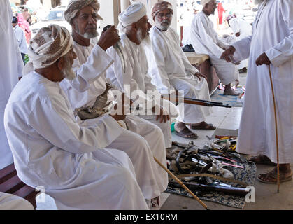 Beduinen (Beduinen) Männer, Kauf und Verkauf von Waffen am Markt in Sinaw, Oman Stockfoto