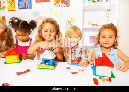 Nette kleine Kinder spielen mit Kunststoffblöcke Stockfoto