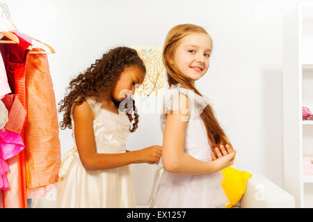 Afrikanische Mädchen hilft ein weißes Kleid passen Stockfoto