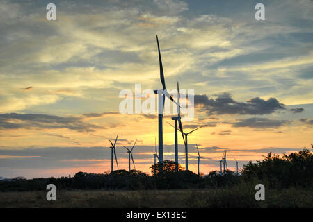 Windenergieanlagen gegen einen wunderschönen Sonnenuntergang im zentralen Tiefland von Panama Stockfoto