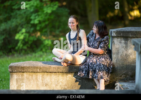 Teenager-Mädchen im Gespräch im Park mit seiner Großmutter. Stockfoto