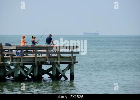 Zwei Frauen und ein Mann fischen von einem Pier in Cape Charles, Virginia, USA. Stockfoto