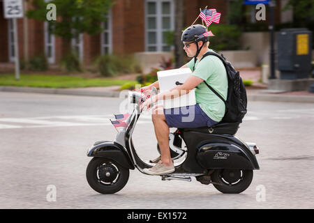 Ein Mann trägt einen Kühler auf seinem Roller fährt während der Daniel Insel Independence Day Parade 3. Juli 2015 in Charleston, South Carolina mit amerikanischen Flaggen dekoriert. Stockfoto