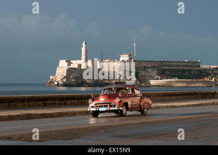 Havanna, Kuba - 18. Mai 2011: Kubanische Taxi fährt vor der el Morro Lighhouse entlang des Malecon in Zentral-Havanna. Stockfoto