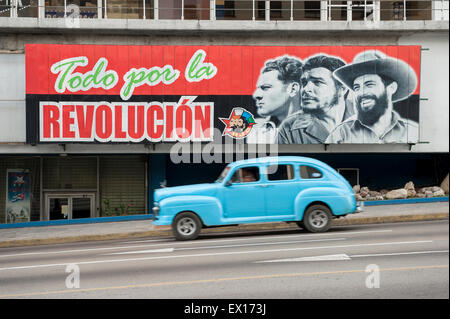 Havanna, Kuba - Juni 2011: American Vintage taxi Auto Pässe unter Förderung der kommunistischen Propaganda im Bereich La Rampa Plakatwand. Stockfoto