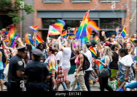 NEW YORK CITY, USA - 28. Juni 2015: Zelebranten auf die jährliche Homosexuell Stolz Parade Welle Regenbogenflaggen Polizei vorbei. Stockfoto