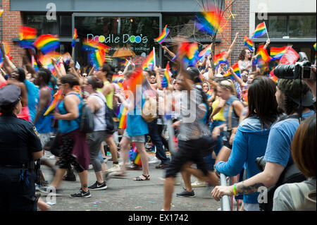 NEW YORK CITY, USA - 28. Juni 2015: Zelebranten auf die jährliche Homosexuell Stolz Parade Welle Regenbogenflaggen Zuschauern vorbei. Stockfoto