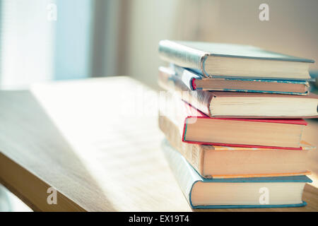 Bücher auf dem Tisch vor Sonnenlicht. Geringe Schärfentiefe. Stockfoto