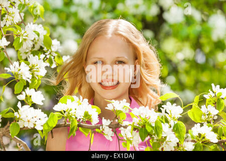 Blondie-Teenager-Mädchen mit weißen Birne Baum Blumen Stockfoto