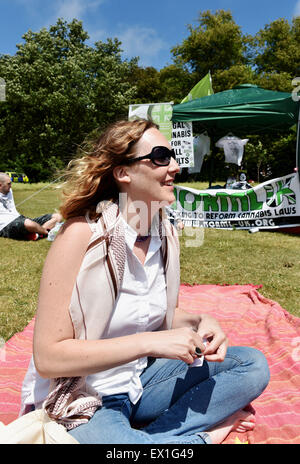 Brighton UK Samstag, 4. Juli 2015 - eine junge Frau genießt die entspannte Atmosphäre auf der Green Pride pro Cannabis-Event in Preston Park Brighton heute die Veranstaltung, organisiert von Brighton Cannabis Club die Legalisierung von medizinischem Cannabis, Cannabis, Hanf und alles grün mit vielen von ihnen offen ins Rollen und Rauchen Gelenke im Park feiern fördern soll Stockfoto